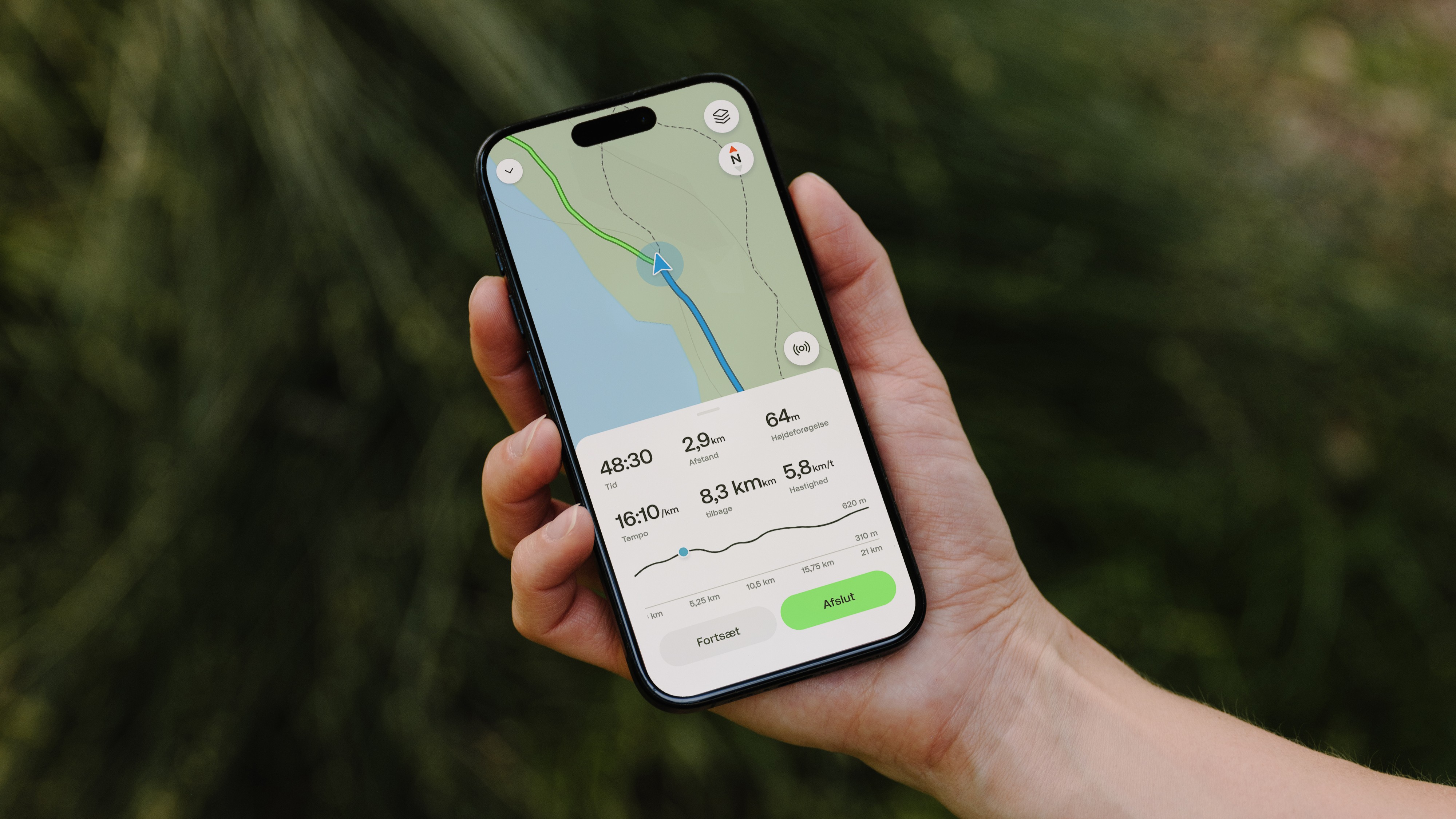 A hiker's hand holding a phone with an AllTrails route on the screen