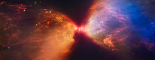 NASA, ESA, CSA, SL1527, shown in this image from NASA’s James Webb Space Telescope’s MIRI (Mid-Infrared Instrument), is a molecular cloud that harbors a protostar. It resides about 460 light-years from Earth in the constellation Taurus. The more diffuse blue light and the filamentary structures in the image come from organic compounds known as polycyclic aromatic hydrocarbons (PAHs), while the red at the center of this image is an energized, thick layer of gases and dust that surrounds the protostar. The region in between, which shows up in white, is a mixture of PAHs, ionized gas, and other molecules. This image includes filters representing 7.7 microns light as blue, 12.8 microns light as green, and 18 microns light as redTScI