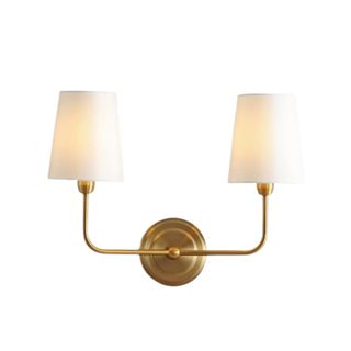 A dual wall sconce with a gold metal base and two white lampshades
