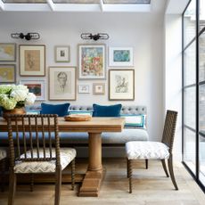 gallery wall ideas with myraid sized artwork on back wall in dining area of an open plan dinign area