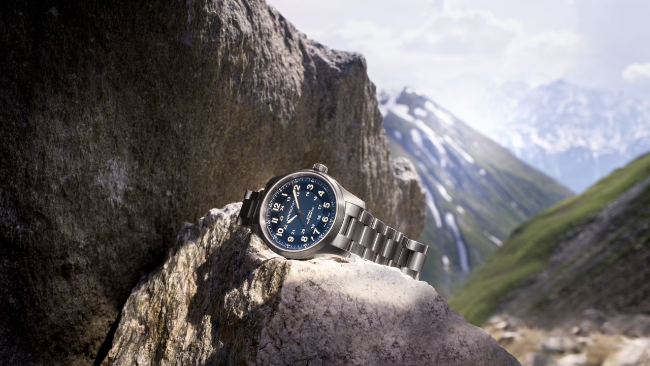 The Hamilton Khaki Field Titanium sat on a rock in front of some mountains