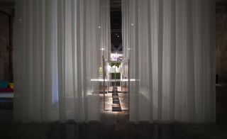 An installation hidden behind semi-transparent curtains