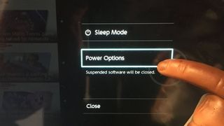 Someone pressing Power Options on the Switch.