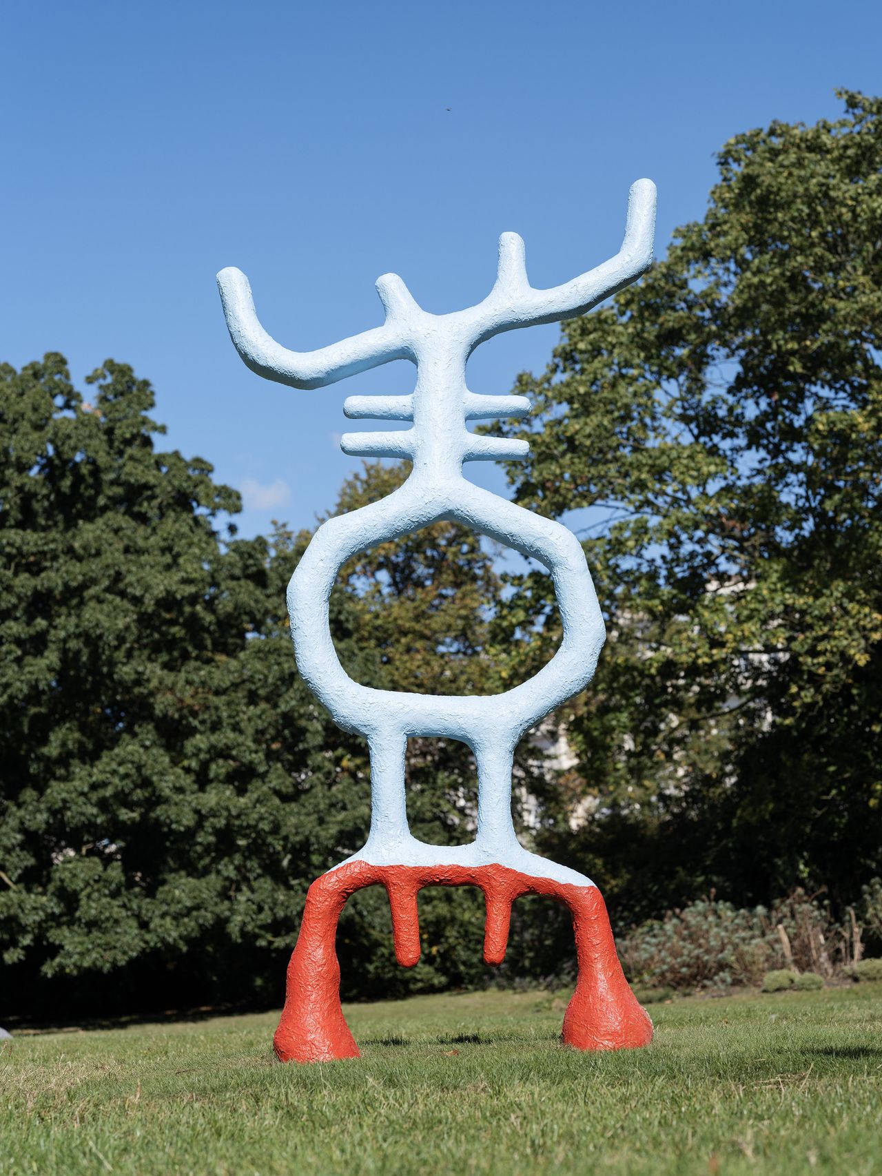 A colossal blue and red sculpture captured in a park.
