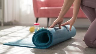 Woman rolling up one of the best yoga mats