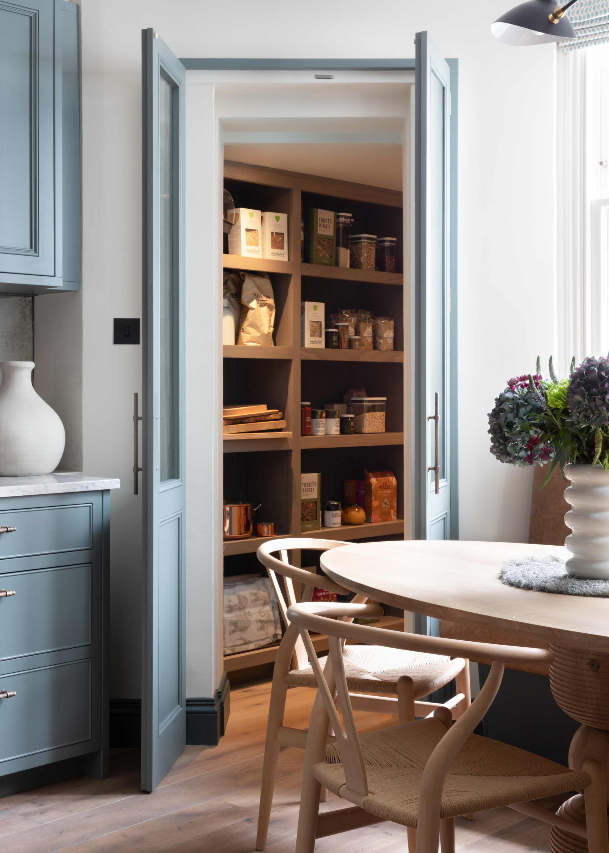 a small pantry with blue double doors off to the side of the dining area