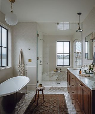 bathroom with grey marble and freestanding tub and large walk in shower