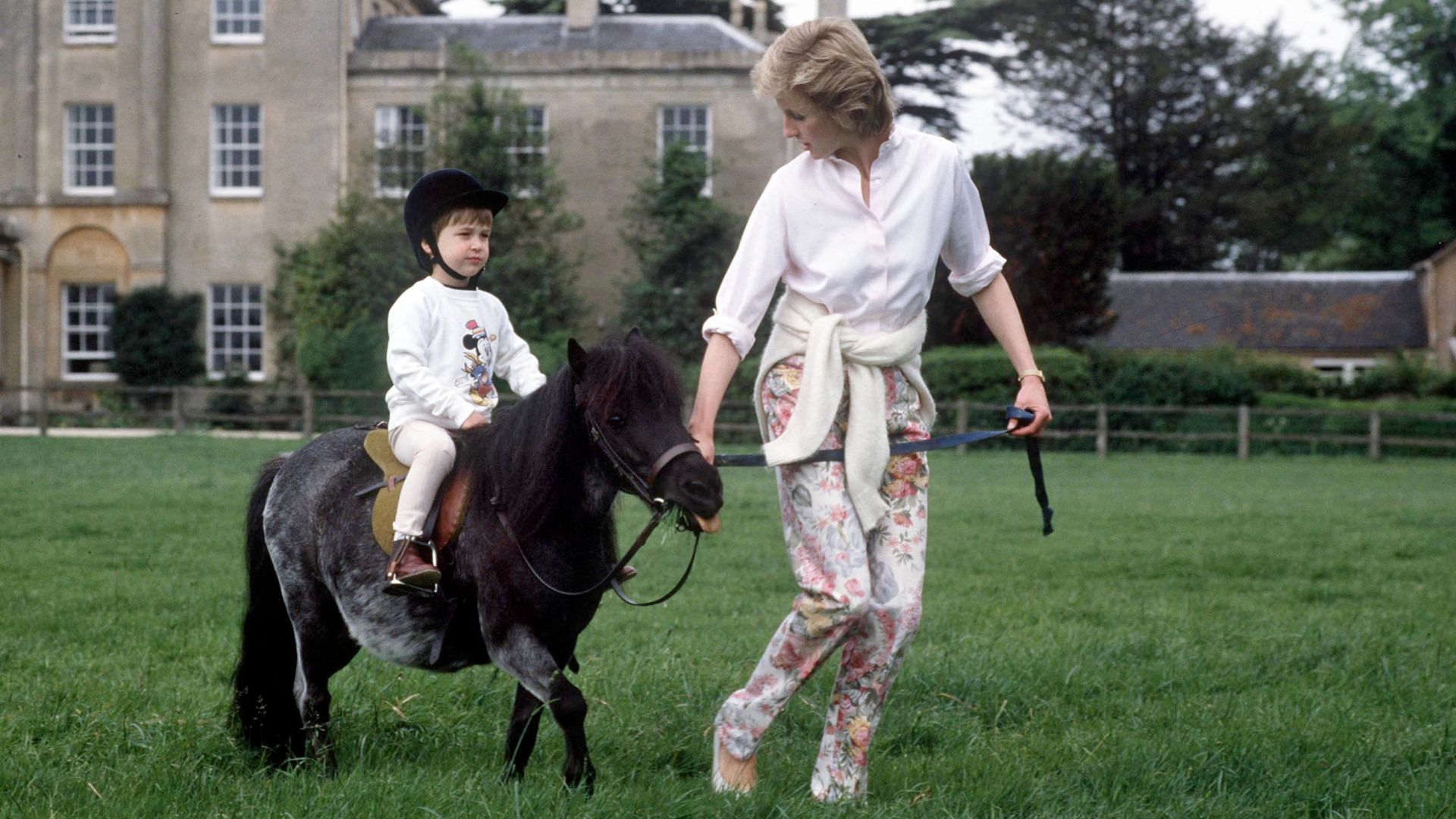 Princess Diana leads a young Prince William around Highgrove Gardens on the back of a pony