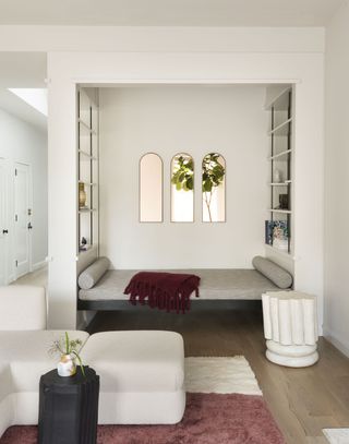 A daybed with three mirrors behind it