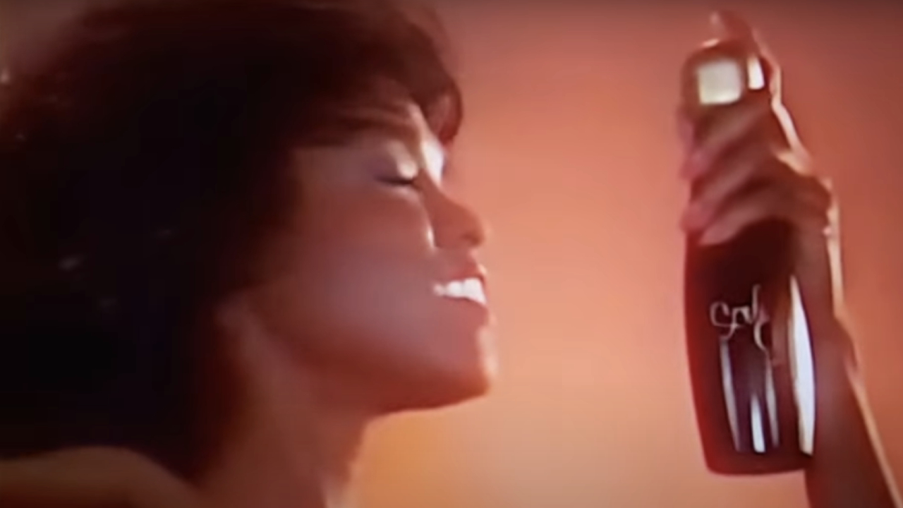 Woman spraying hair in Soul Glo ad from Coming to America