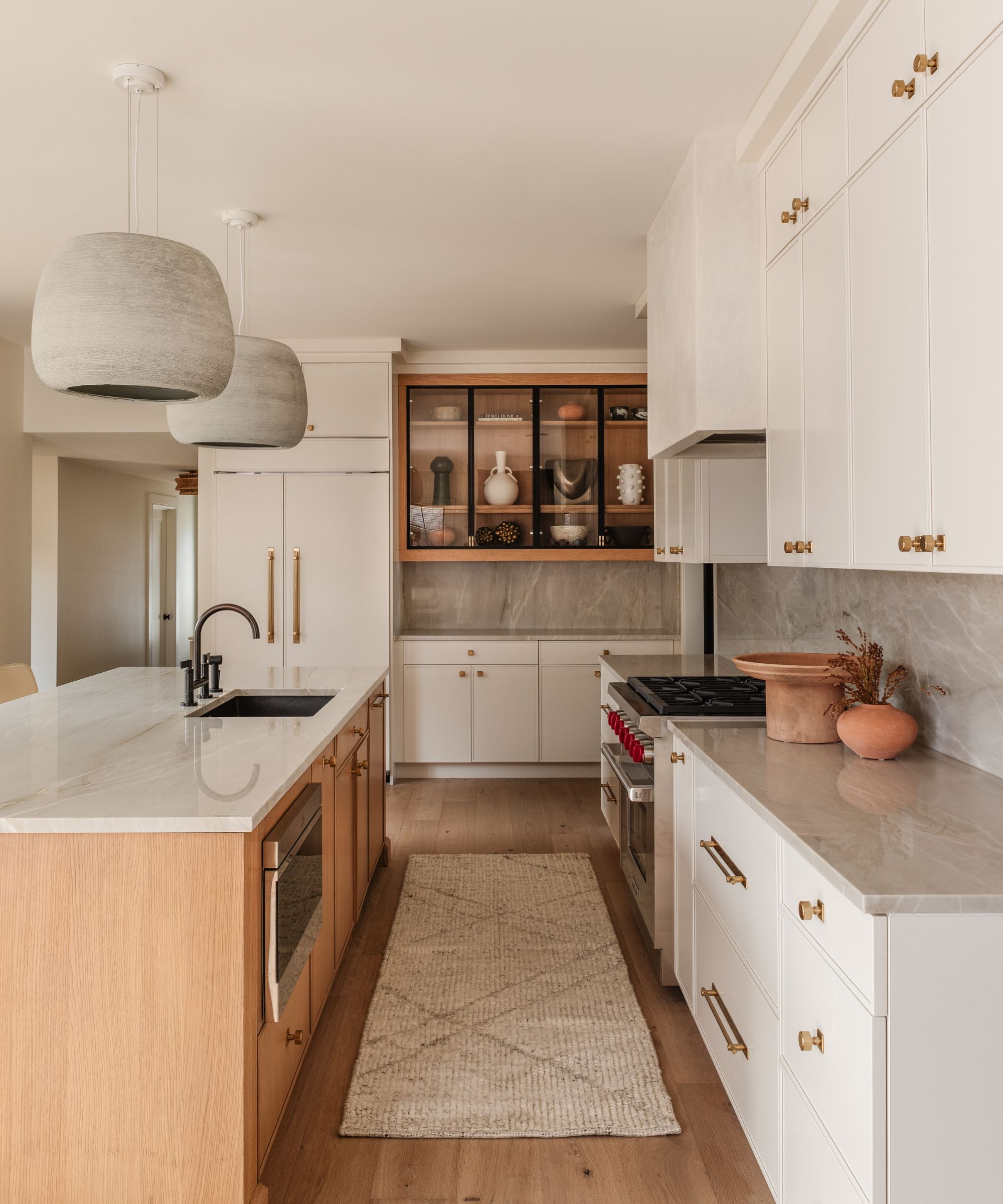 White kitchen with soft gray marble tops and a wooden island