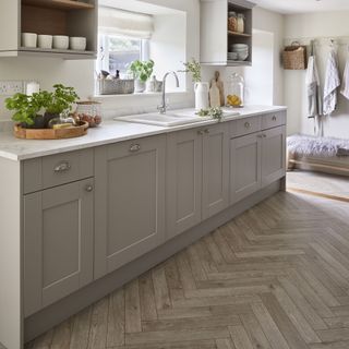Light grey modern kitchen with chevron grey flooring.