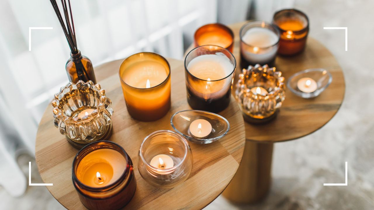 picture of various candles in jars on wooden side tables to support a used candle hack to repurpose jars