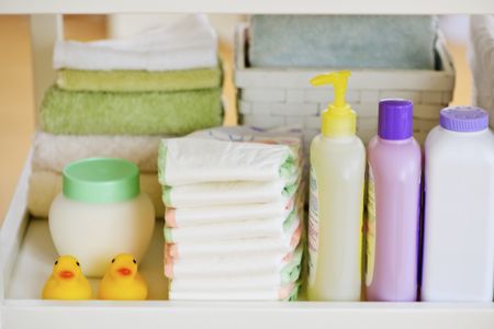 Stack of diapers with baby shampoo, baby lotion and other baby items