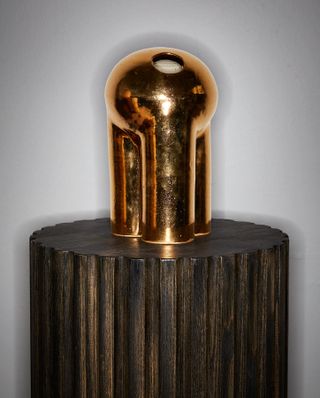 Metal vase on a wood stand