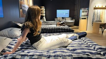 Emilia sitting on a mattress in the Hästens showroom.