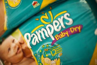 A close-up of a packet of Pampers nappies featuring a baby model