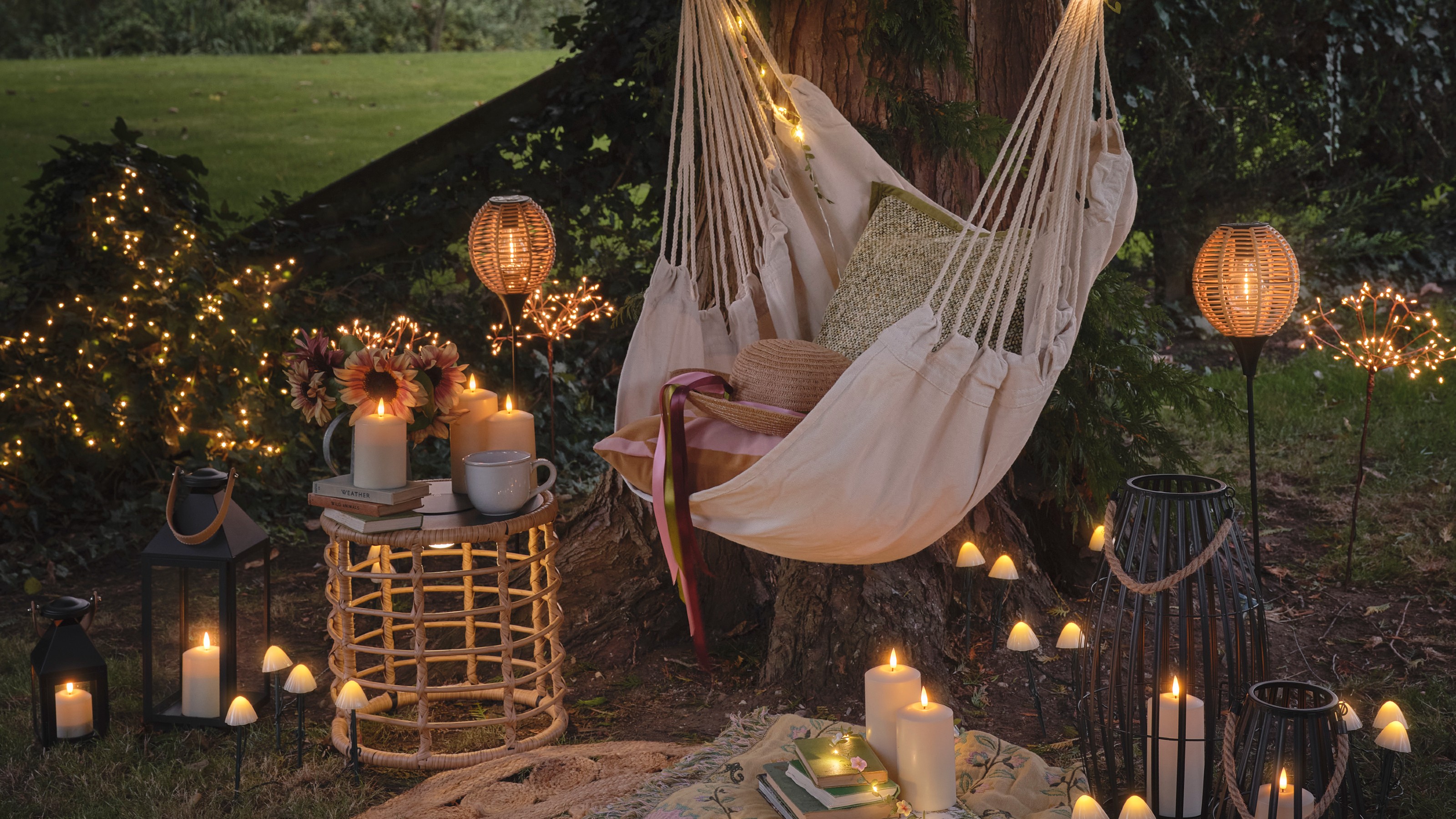 A garden with a hanging garden chair and whimsical lighting from Lights4fun, including solar mushroom stake lights