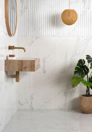 bathroom with wall hung basin and marble lookalike ceramic tile on floor and walls