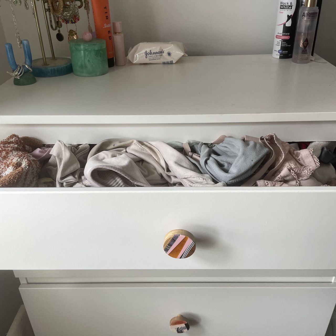 White chest of drawers with underwear spilling out of the top drawer
