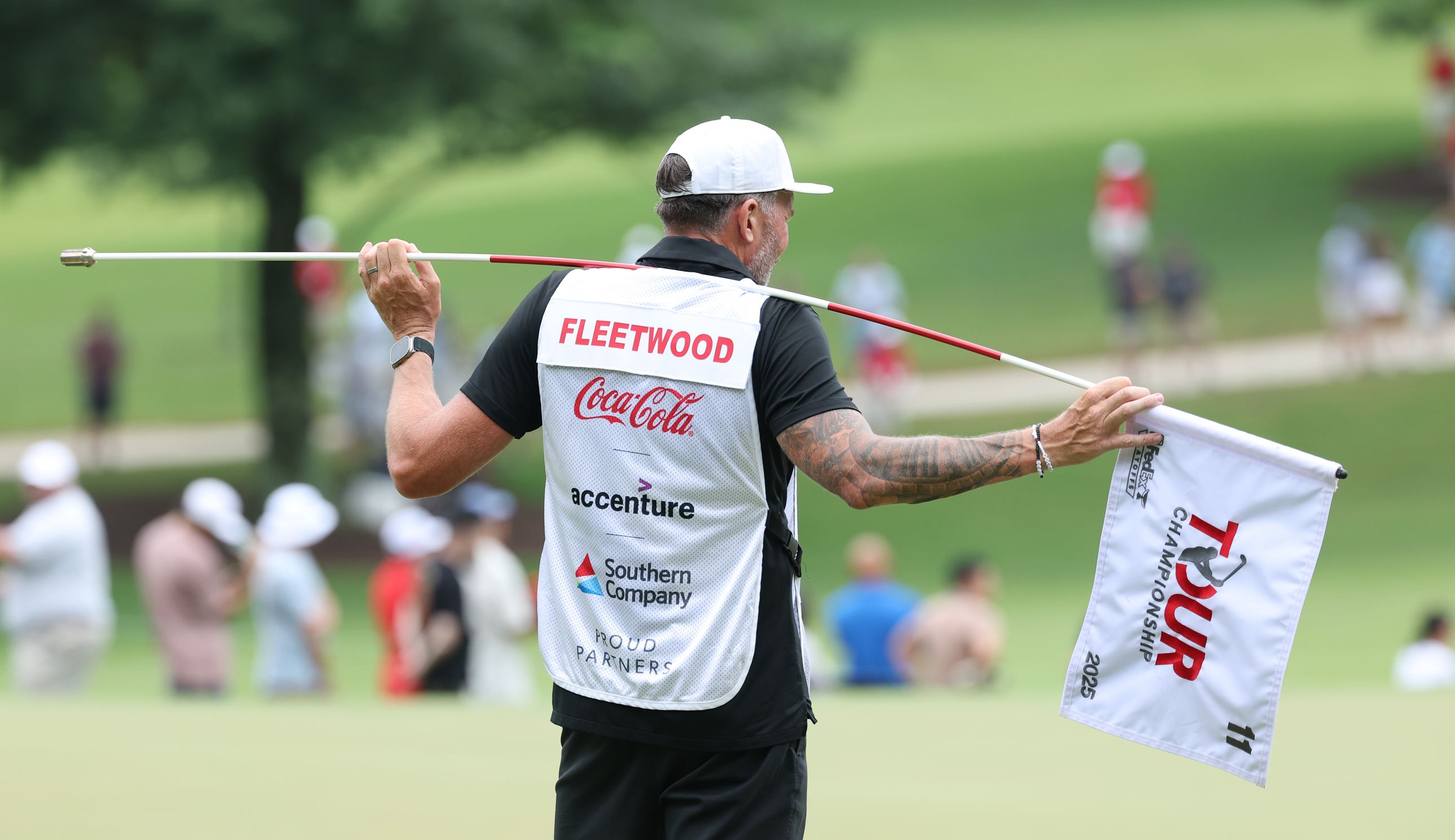 Tommy Fleetwood&#039;s caddie holds a Tour Championship flag