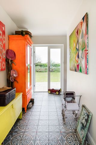 Hallway with bold tiled floor and colourful storage
