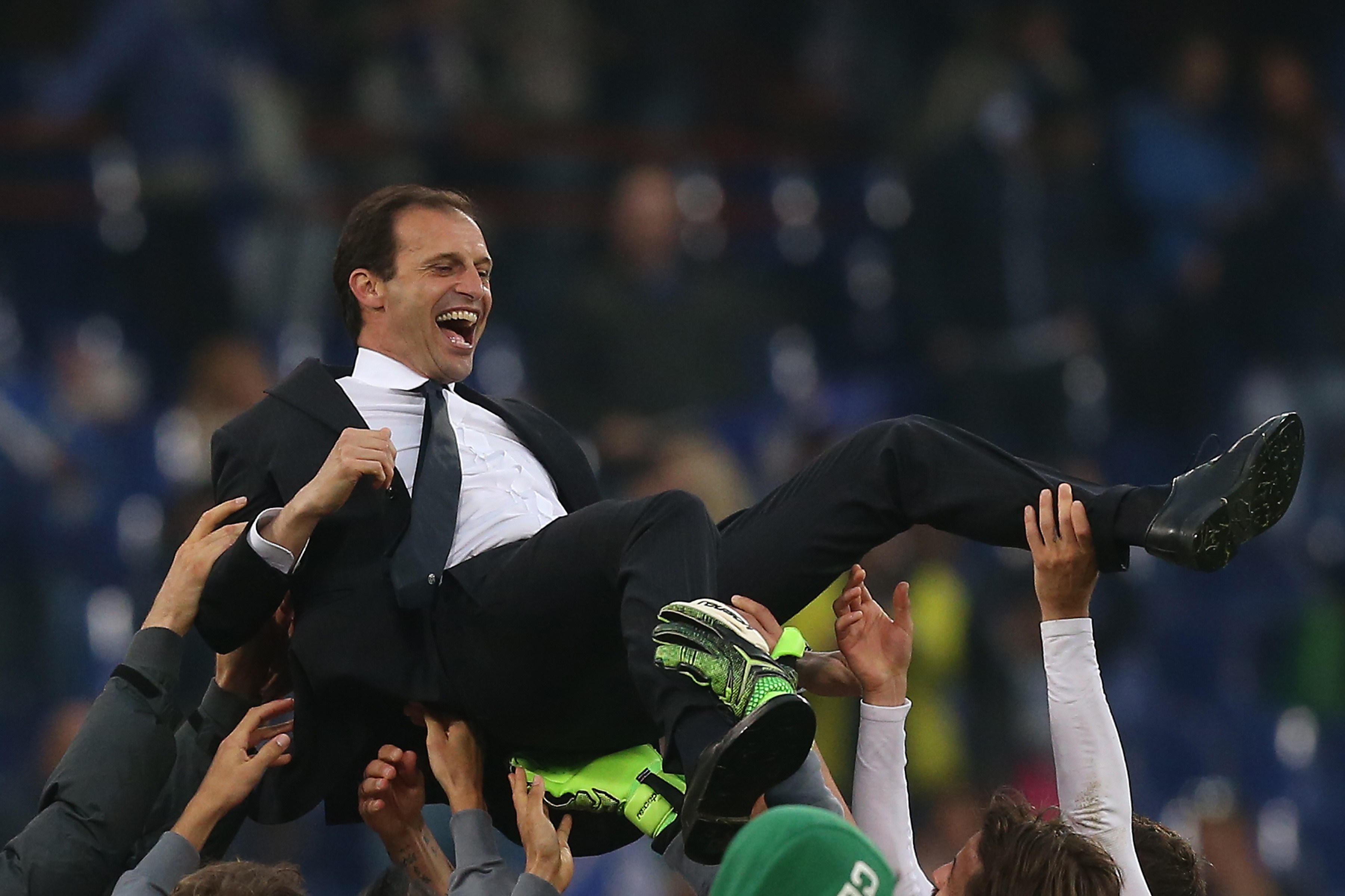 Juventus coach Massimiliano Allegri is lifted in the air by his players after winning the Scudetto in May 2015.