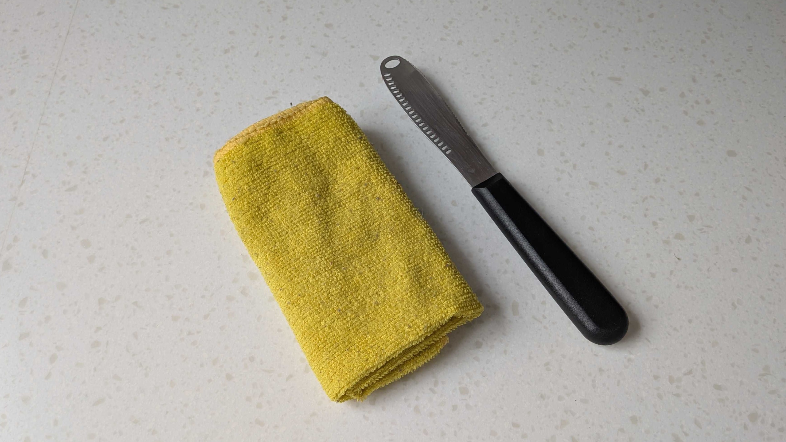 Yellow cloth and butter knife on countertop
