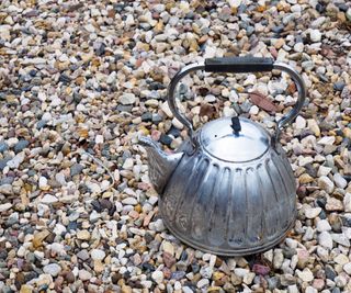 Kettle on gravel to kill weeds with boiling water
