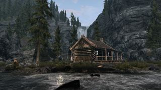Best Skyrim mods — a woodland cabin beside a waterfall-fed stream.