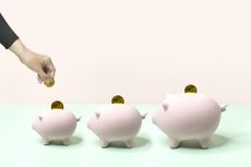 Hand inserting coins into three piggy banks of different size.