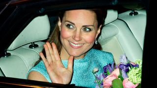Kate Middleton wears a green dress and holds flowers as she's driven away