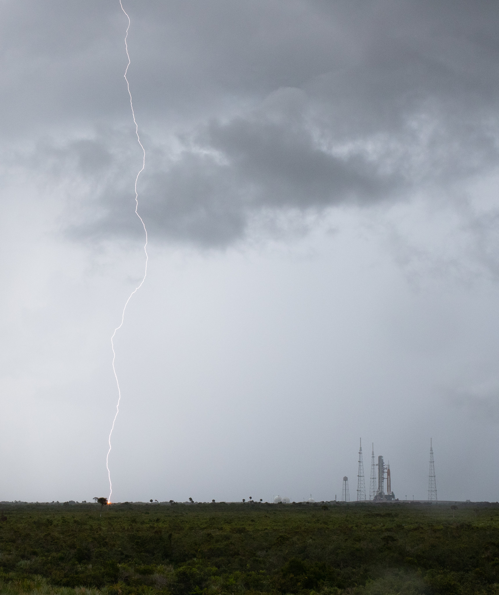 lightning to the left of a launch pad