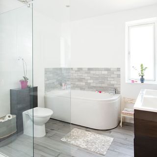 bathroom with white wall grey designed floor and white bathtub