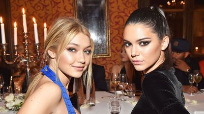 Blonde and black haired models sitting down and posing