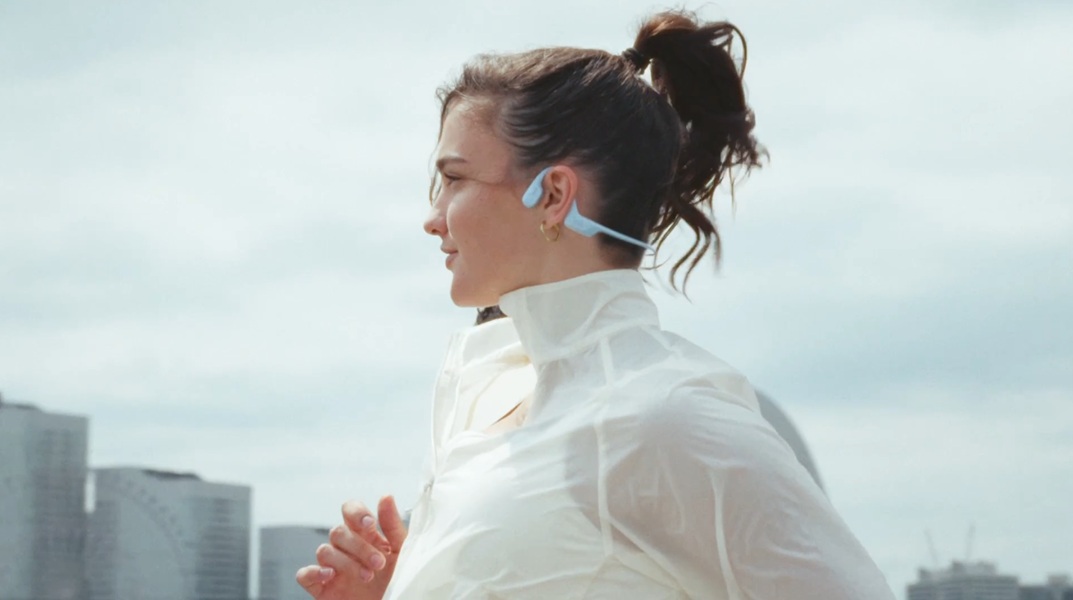 A model running with the Shokz OpenRun Air 2 around her ears.