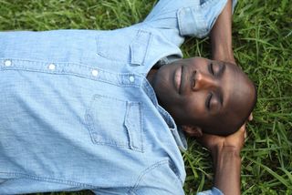 A man sleeps on the grass.