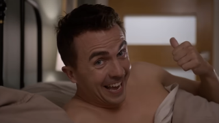 Malcolm shirtless in bed pointing back to bathroom with his thumb in Malcolm in the Middle: LIfe's Still Unfair