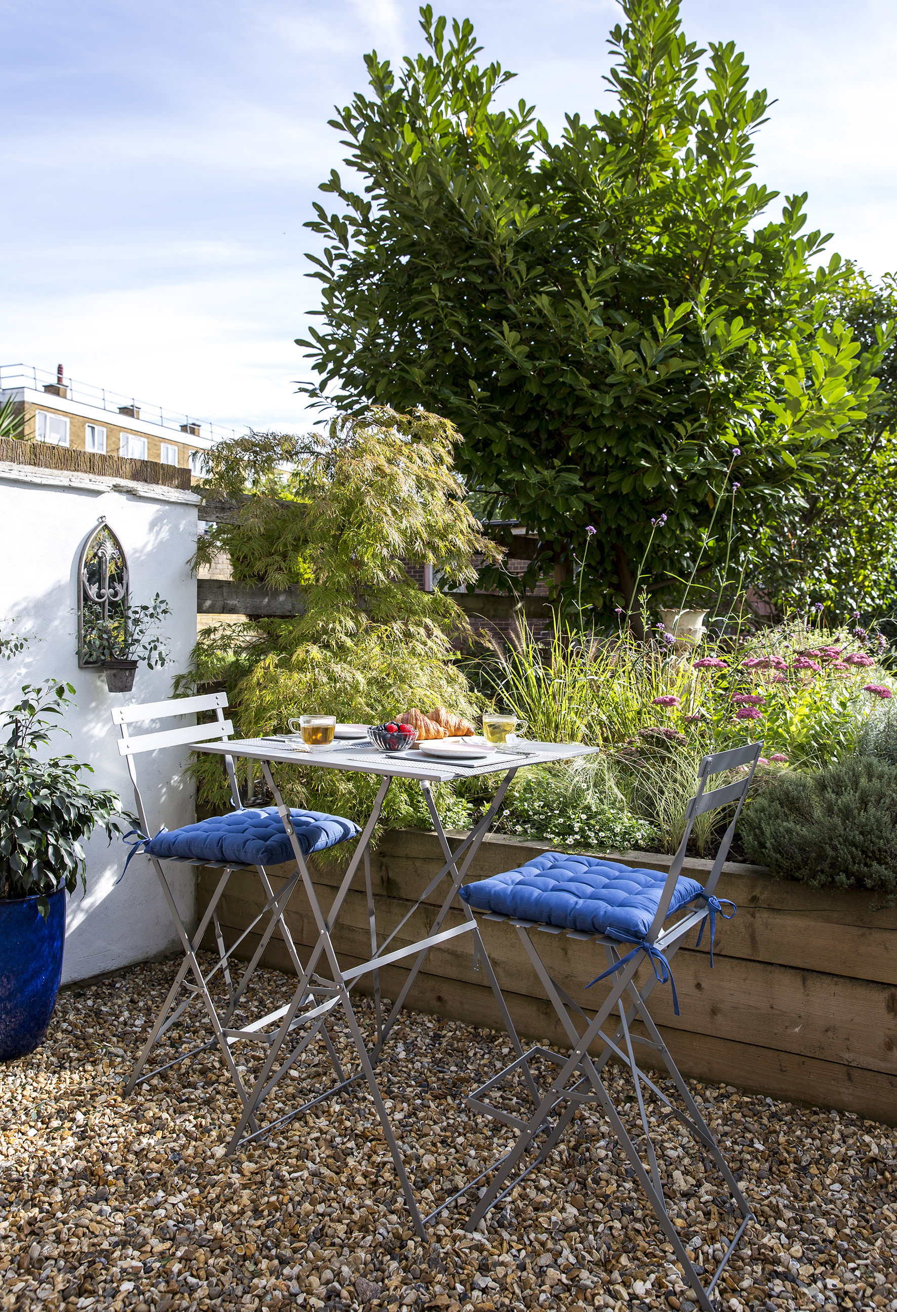 Bistro set in seating area with raised planters