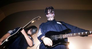 Mick Thomson and Jim Root in boilersuits, live onstage in 2000