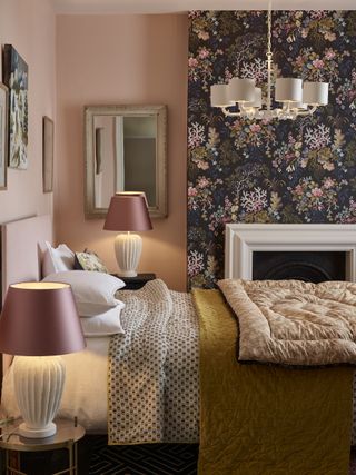 Pale pink bedroom with dark wallpaper panel and white table lamps with pink shades