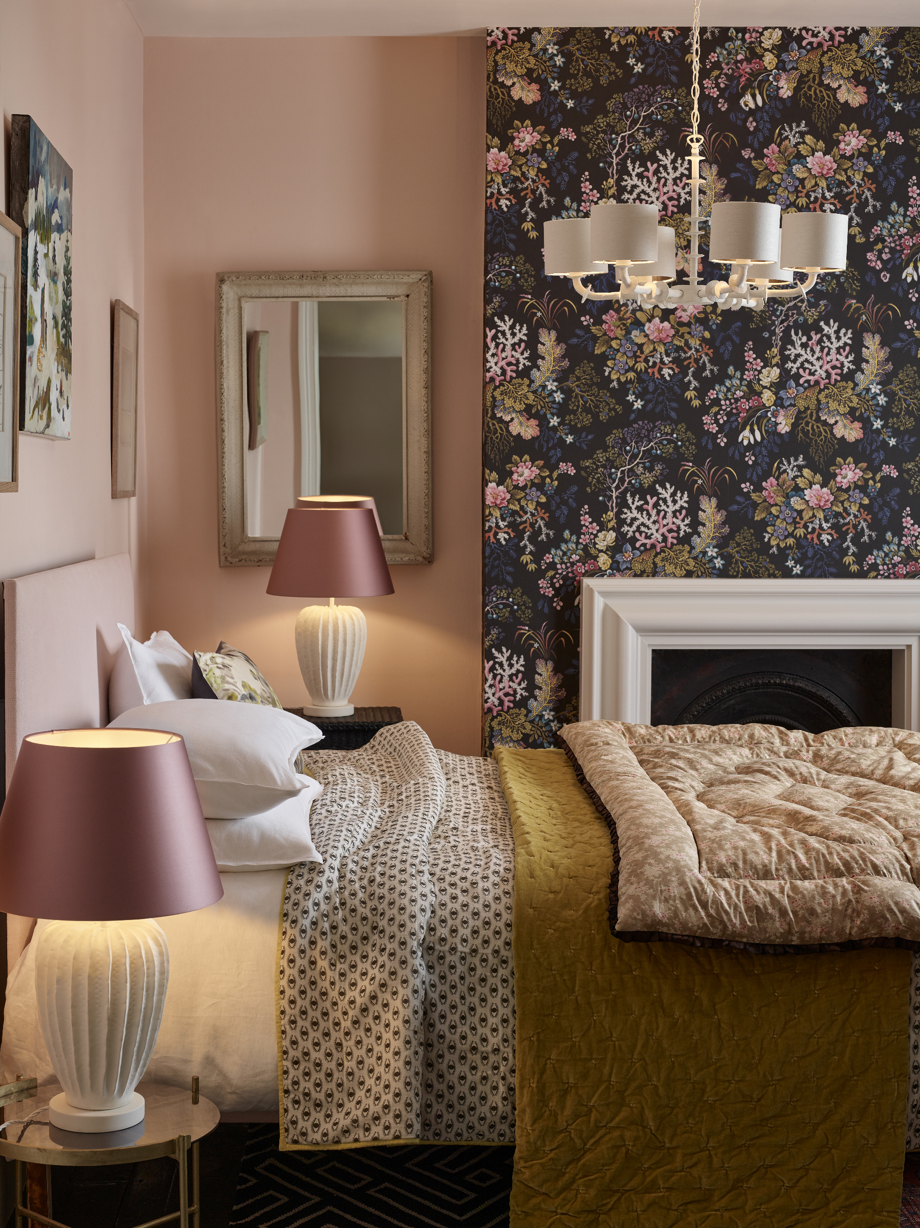 Pale pink bedroom with dark wallpaper panel and white table lamps with pink shades
