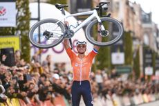 Mathieu van der Poel holds his bike aloft at the finish of the 2024 UCI Gravel World Championships