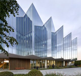 Exterior of AstraZeneca's Discovery Centre by Herzog de Meuron featuring shining and reflective glass all around