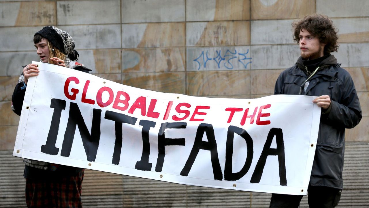 Protesters hold a banner saying Globalise the Intifada during a demonstration in the centre of Manchester