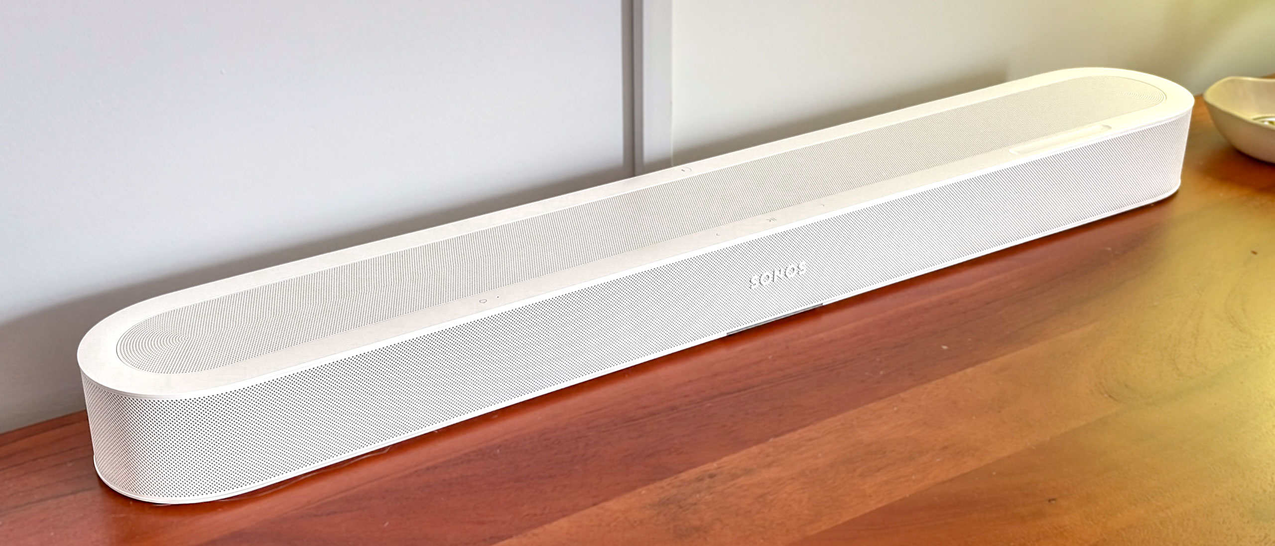 A Sonos Beam Ultra soundbar on a side table