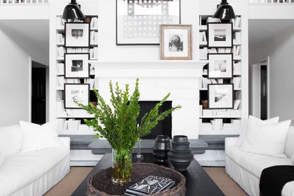 a white living room with books and photographs