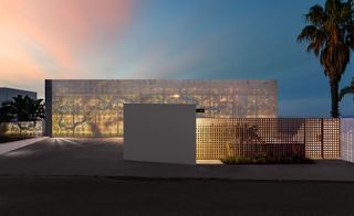 At dusk, the house can be lit to show the patterned perforations of the aluminium screen