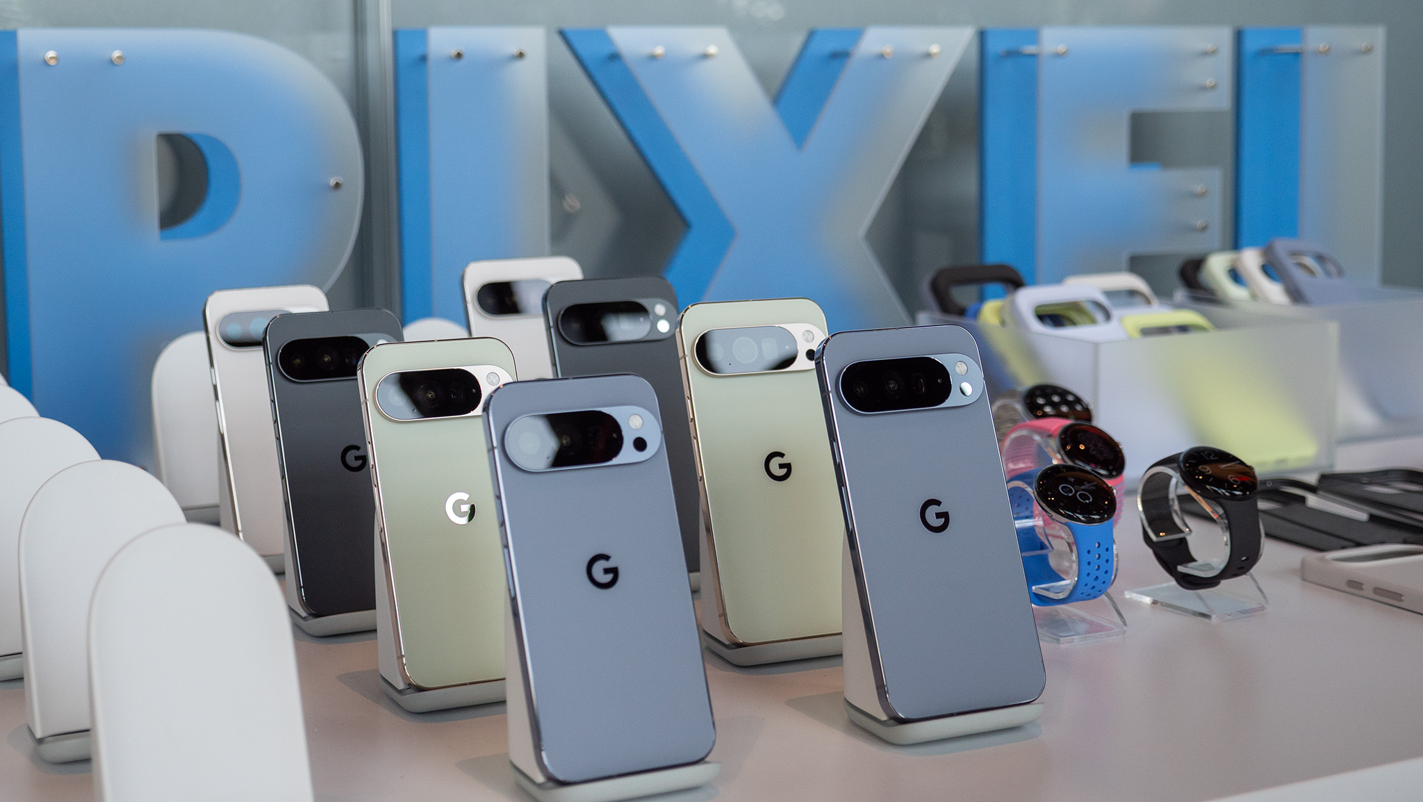 All colors of the Google Pixel 10 Pro and Pro XL line with a &quot;PIXEL&quot; sign behind them