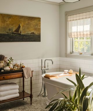 bathroom with freestanding tub and ship painting